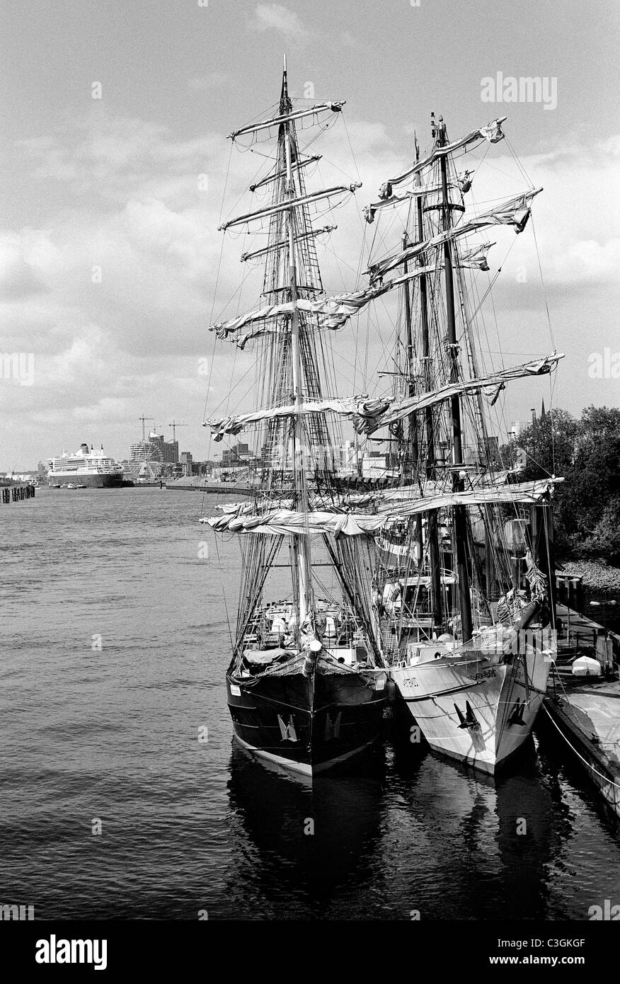 Großsegler Mercedes und Artemis mit Queen Mary 2 und Elbphilharmonie zuhinterst im Hamburger Hafen. Stockfoto