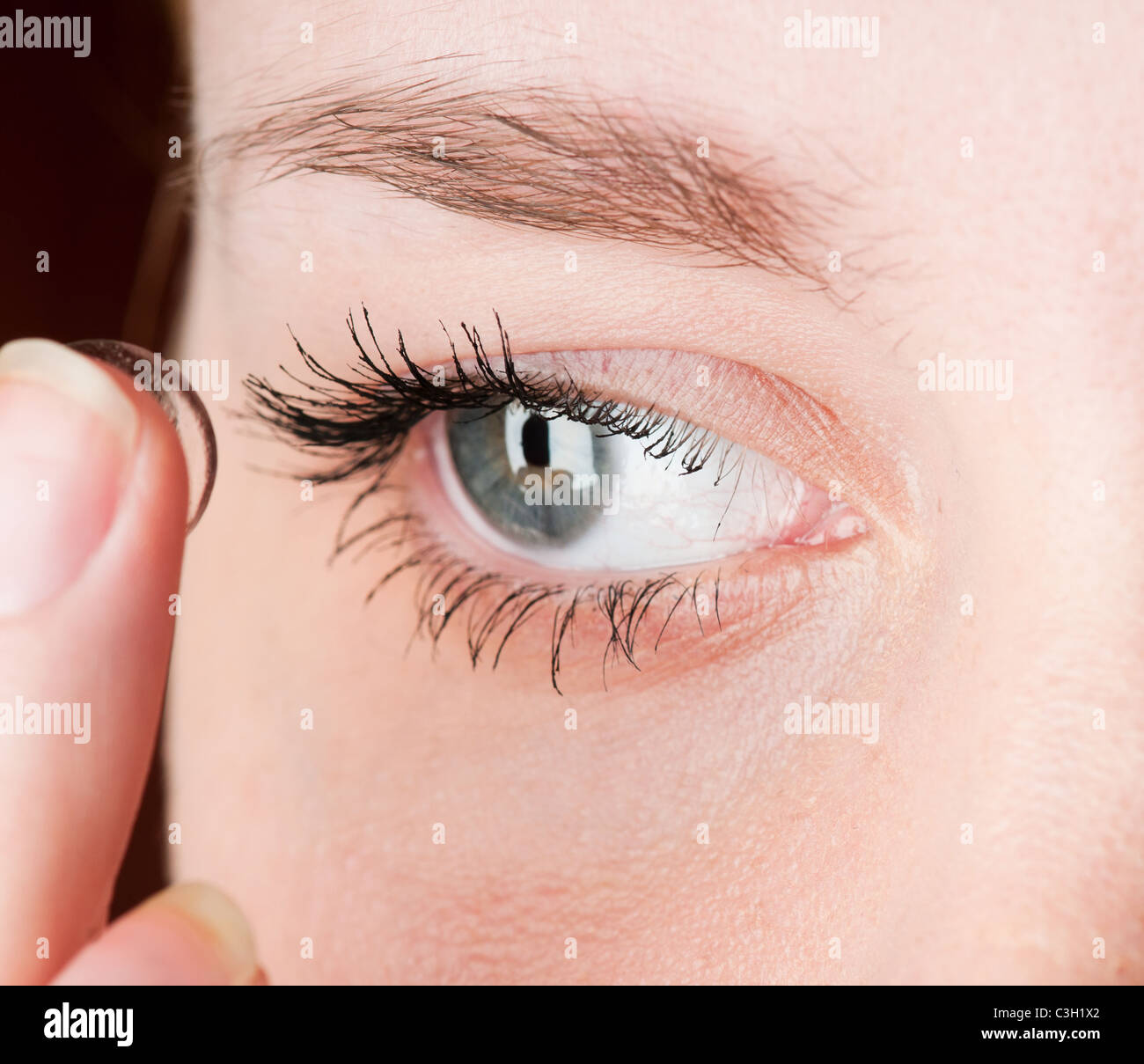 Nahaufnahme des Einsetzens einer Kontaktlinse in weibliche Auge Stockfoto