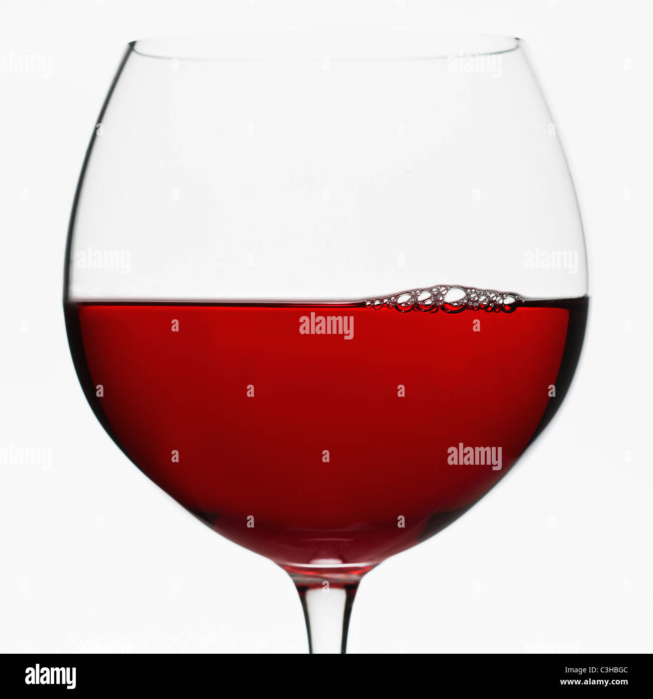 Nahaufnahme von Glas Rotwein auf weißem Hintergrund Stockfoto