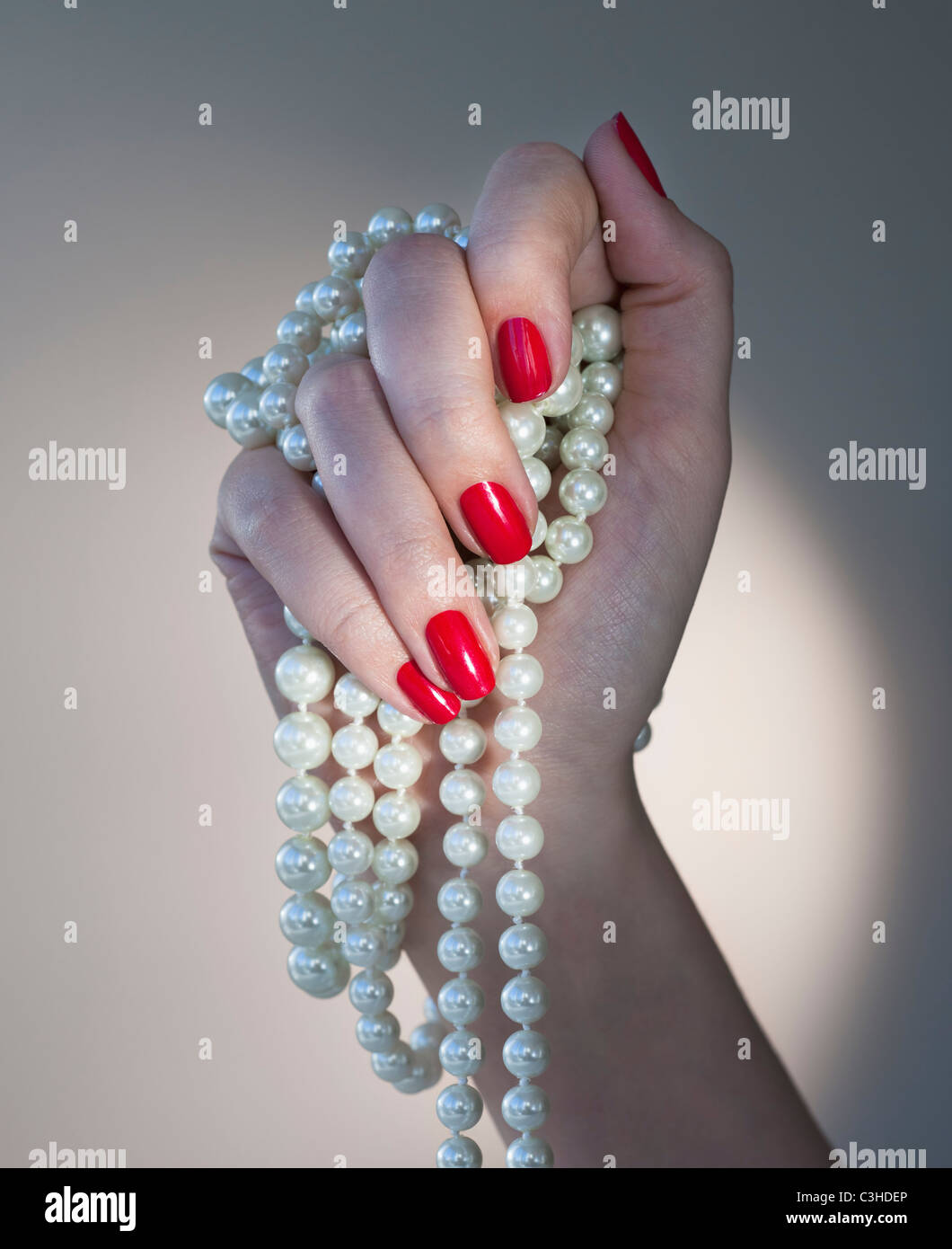 Nahaufnahme von Frauenhand mit rotem Nagellack hält Perlen Stockfotografie  - Alamy