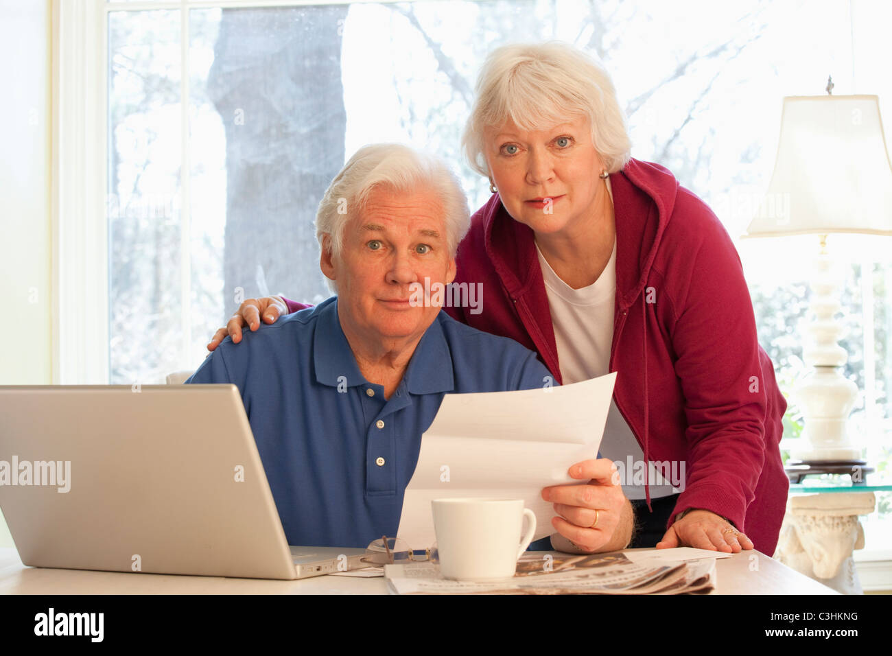 Porträt von älteres Paar, die Zahlung von Rechnungen mit laptop Stockfoto