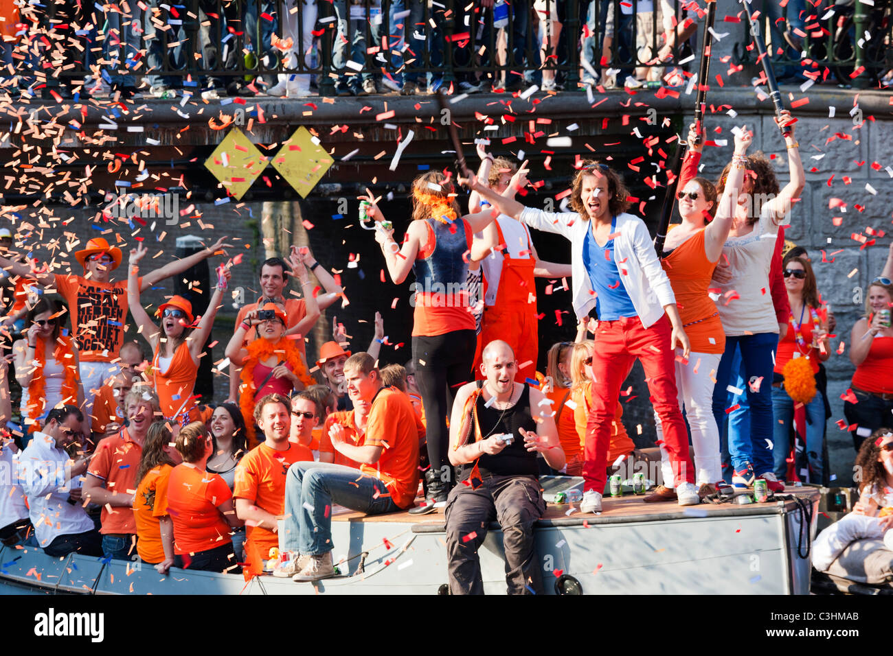 Königstag, der Geburtstag des Königs, ehemals Königinnentag. Amsterdam Canal Parade Boote Menschen feiern schießen orangefarbene Konfetti. Stockfoto