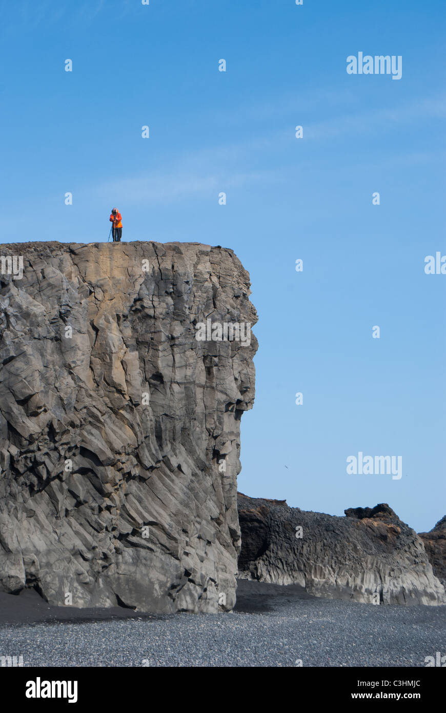 Fotograf auf säulenförmigen Basaltfelsen Stockfoto