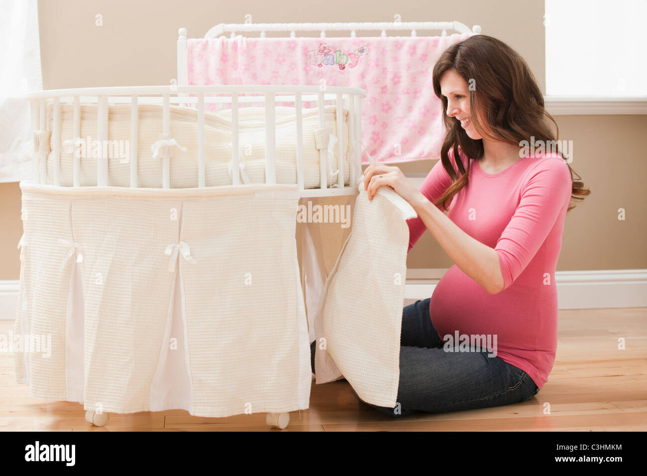 Junge schwangere Frau Laufstall für neues Baby vorbereiten Stockfoto