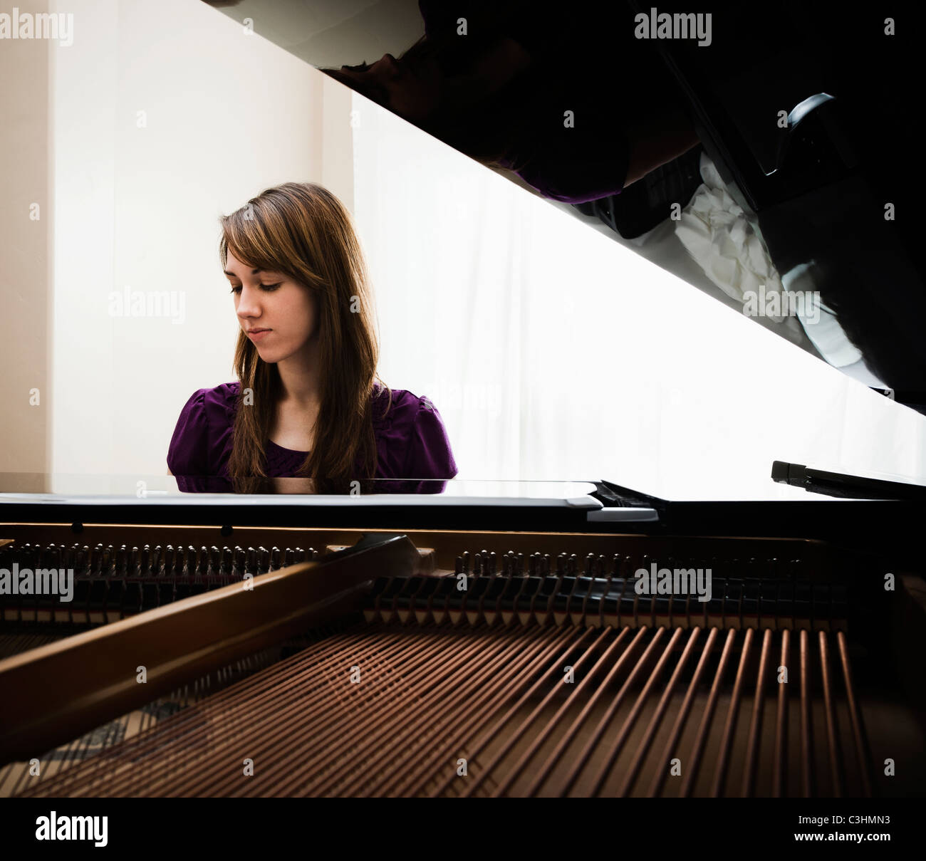 Junge Frau spielen Grand piano Stockfoto