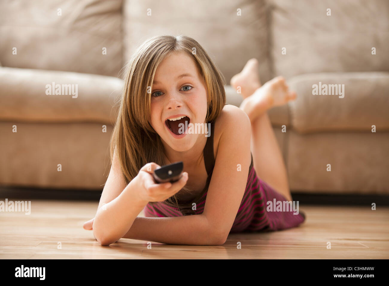 Mädchen (10-11) auf Boden liegend, vor dem Fernseher Stockfoto