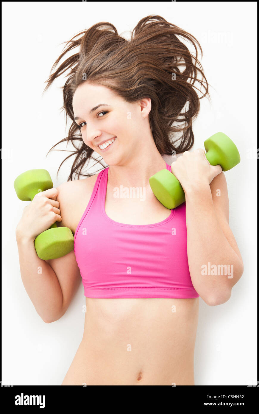 Studio-Porträt der jungen Frau mit Hanteln Stockfoto