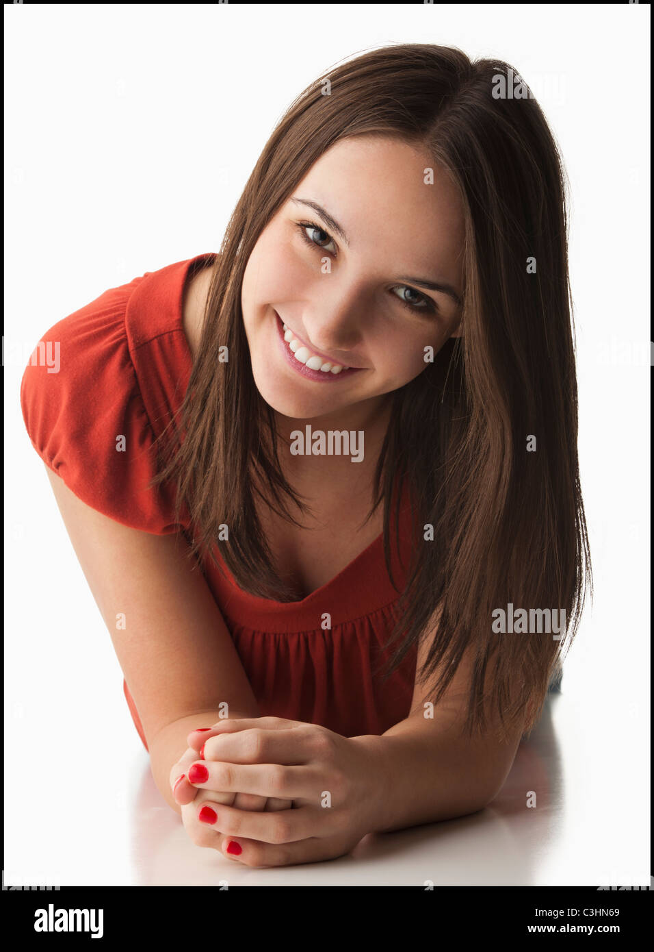 Studio-Porträt der jungen Frau im liegen, lächelnd Stockfoto