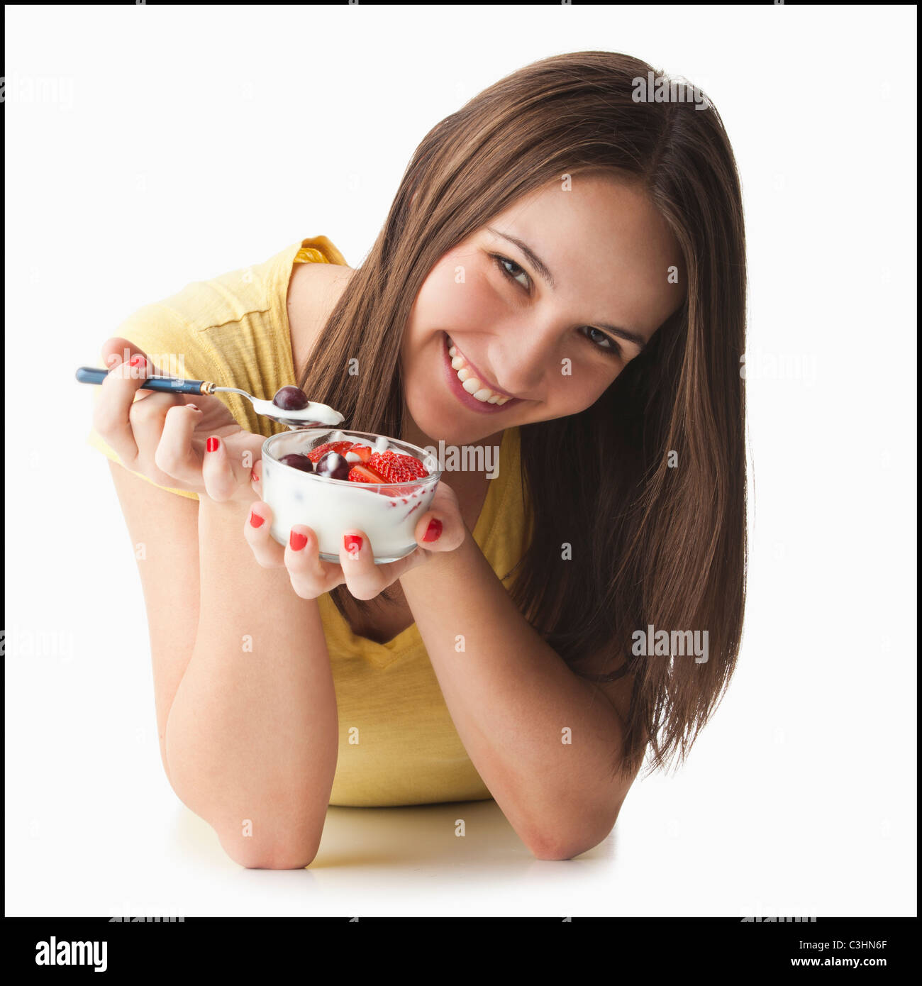 Studio-Porträt der jungen Frau Essen Erdbeeren und Joghurt Stockfoto