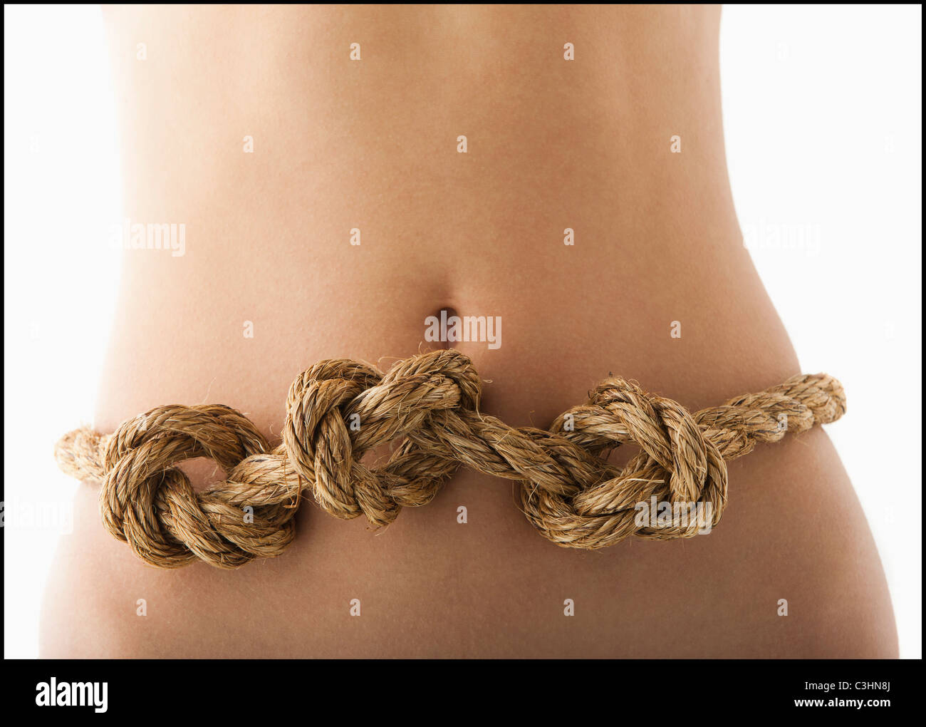 Junge Frau mit Knoten im Magen Stockfoto