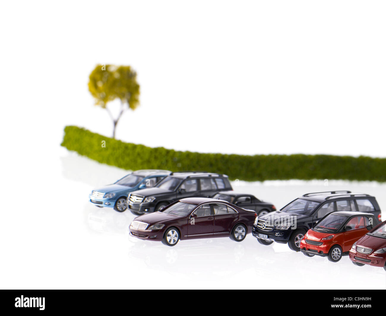 Reihe von verschiedenen Autos geparkt in der Nähe von Feld Stockfoto