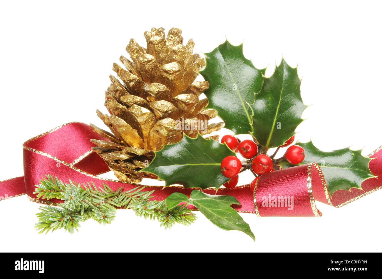 Weihnachtsdekoration von Holly, goldene Tannenzapfen, Tannennadeln und Efeu, umgeben von einem scharfkantigen Goldband Stockfoto