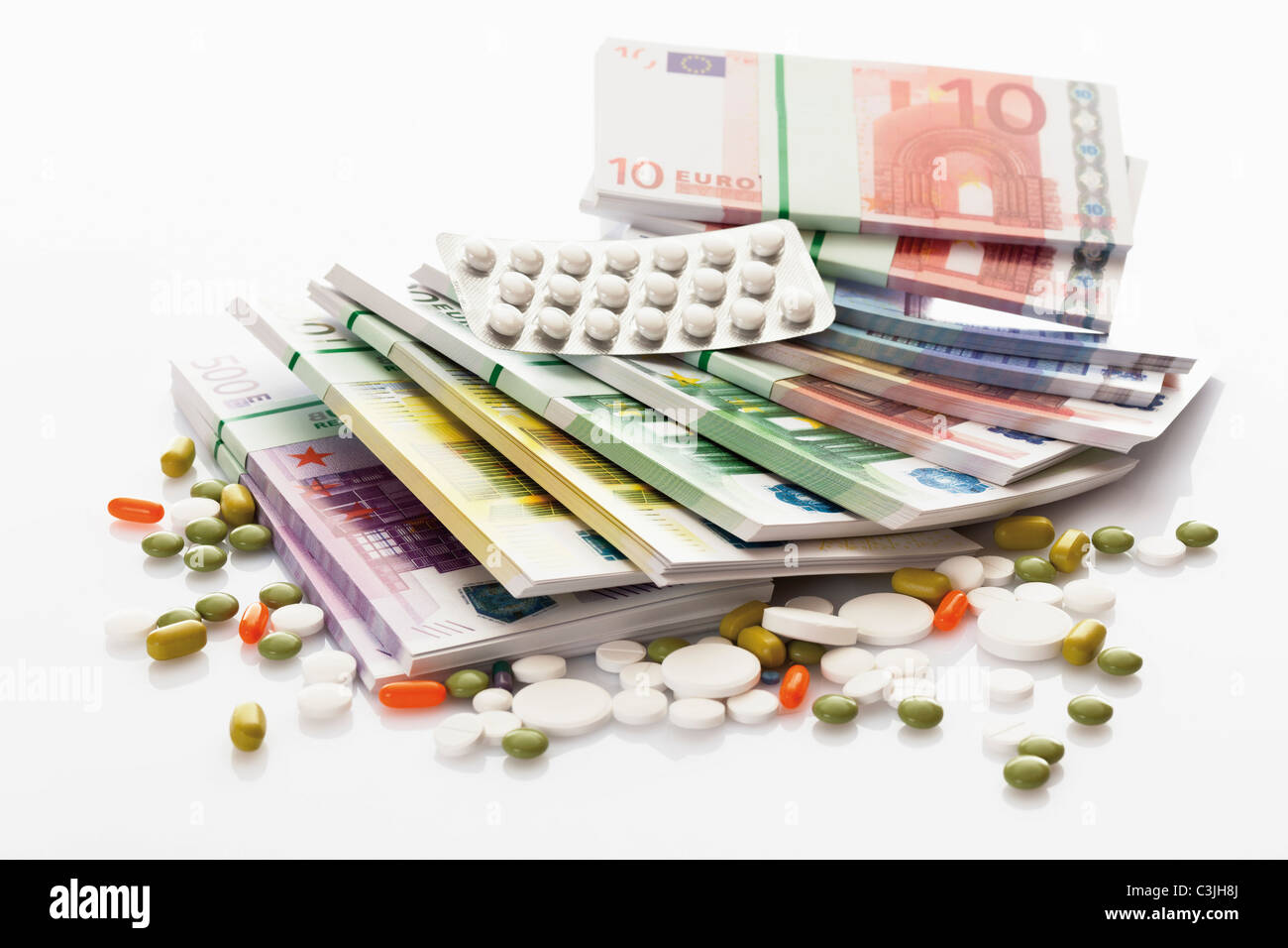 Gemischte Tabletten mit Bündeln von Euro-Banknoten auf weißem Hintergrund Stockfoto