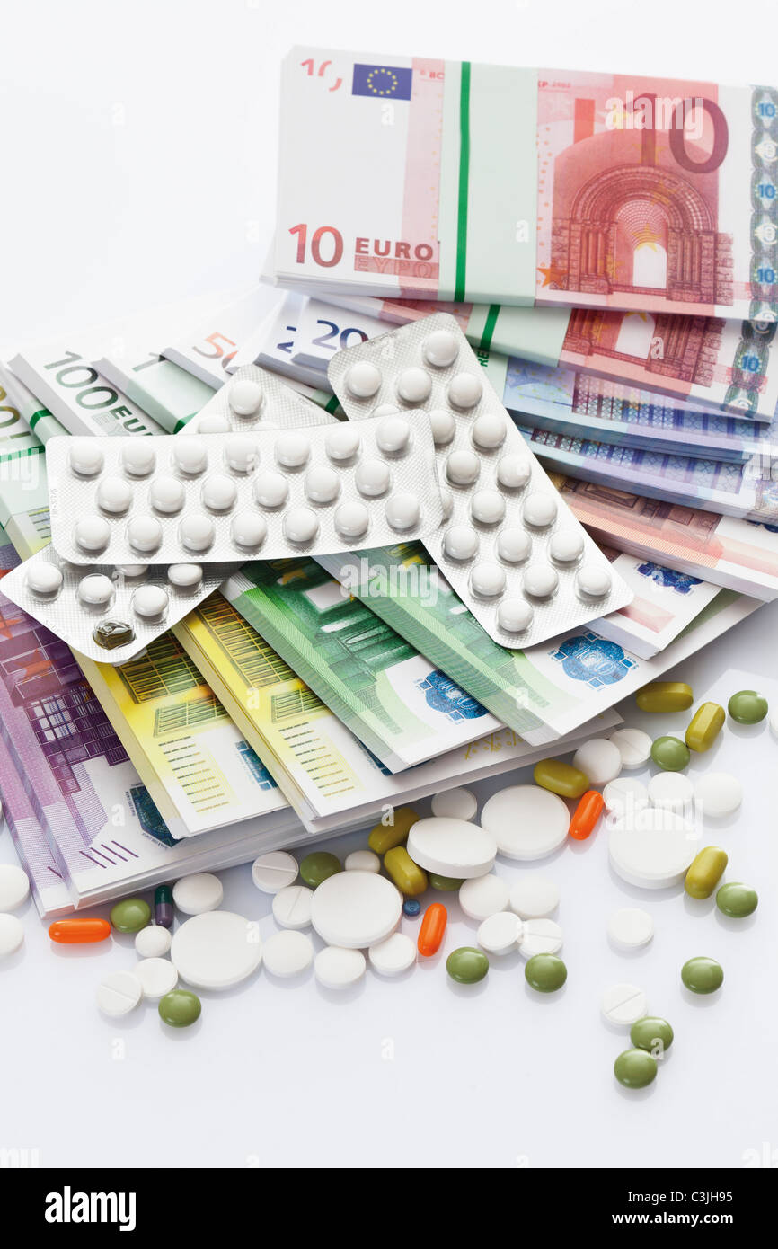 Gemischte Tabletten mit Bündeln von Euro-Banknoten auf weißem Hintergrund Stockfoto