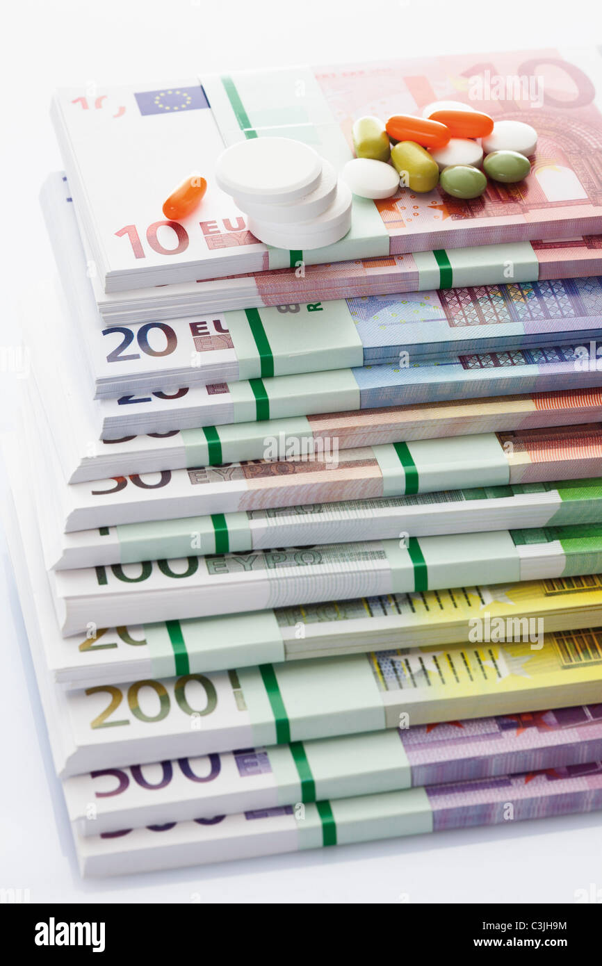 Tabletten auf Stapel von Euro-Banknoten, Nahaufnahme Stockfoto