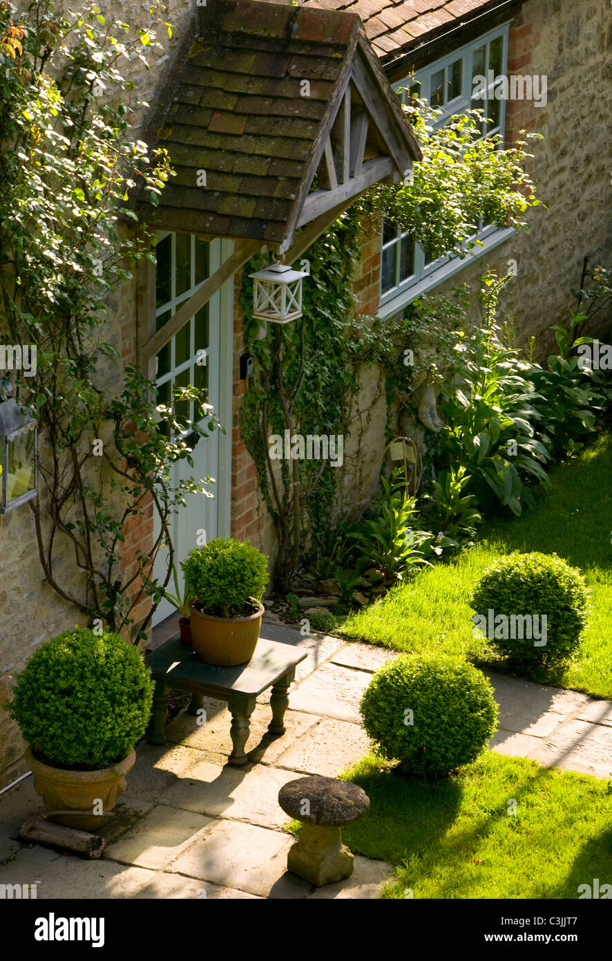 Weg über Rasen eingefasst mit Box Hecke zu Ferienhaus Veranda im englischen Garten Stockfoto
