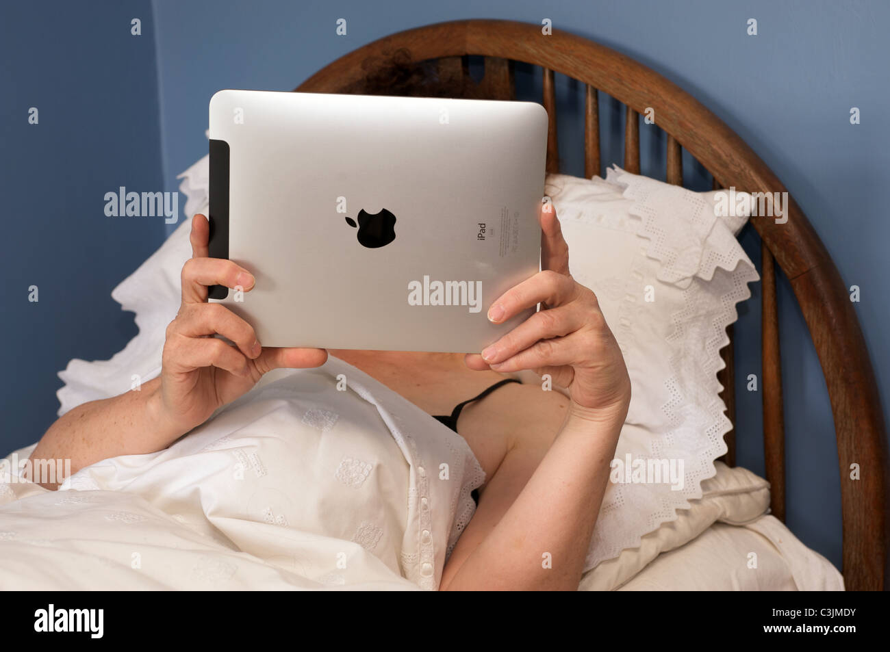 Frau liest ein Buch über ein Apple iPad Tablet-computer Stockfoto