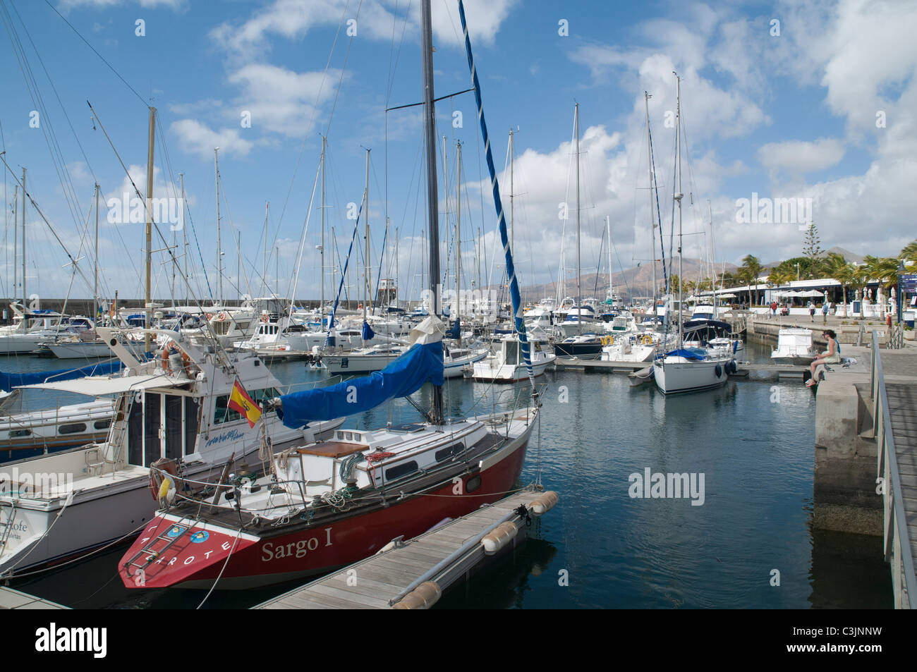 Dh Jachthafen Puerto Calero PUERTO CALERO LANZAROTE Paar sitzt auf Kai Segelyacht im Hafen Marina Steg Boot Stockfoto