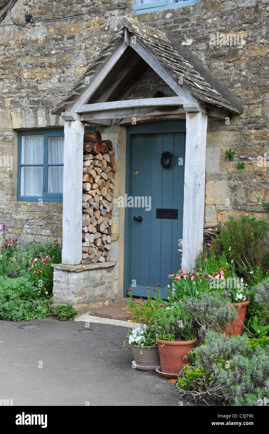Eingangstür zur Hütte zeigt Log Haufen, Lower Slaughter, Gloucestershire Stockfoto