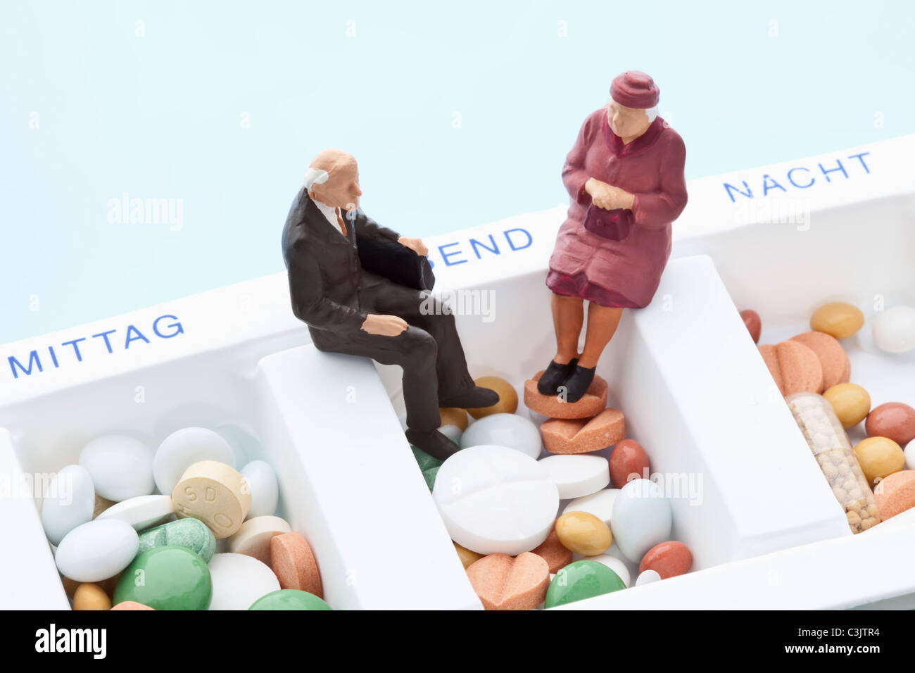 Figuren sitzend auf Pille-organizer Stockfoto