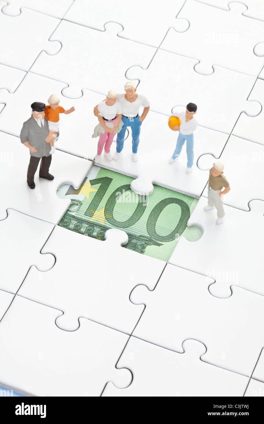 Figur auf Puzzleteil mit 100-Euro-Schein ansehen Stockfoto