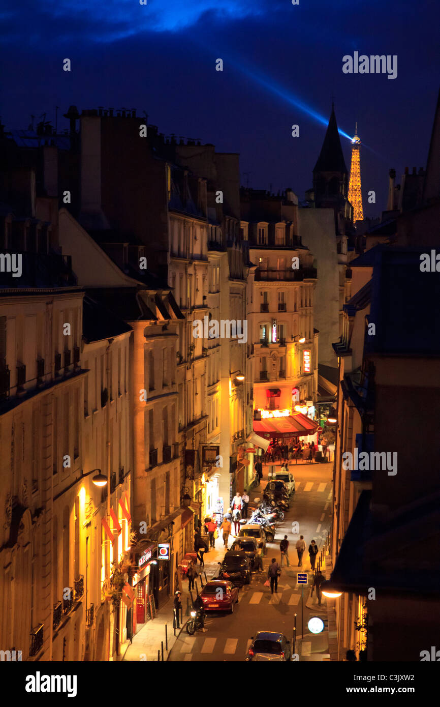 Eine beleuchtete Rue Saint-André des Arts bei Nacht mit dem Eiffelturm im Hintergrund, Paris Stockfoto