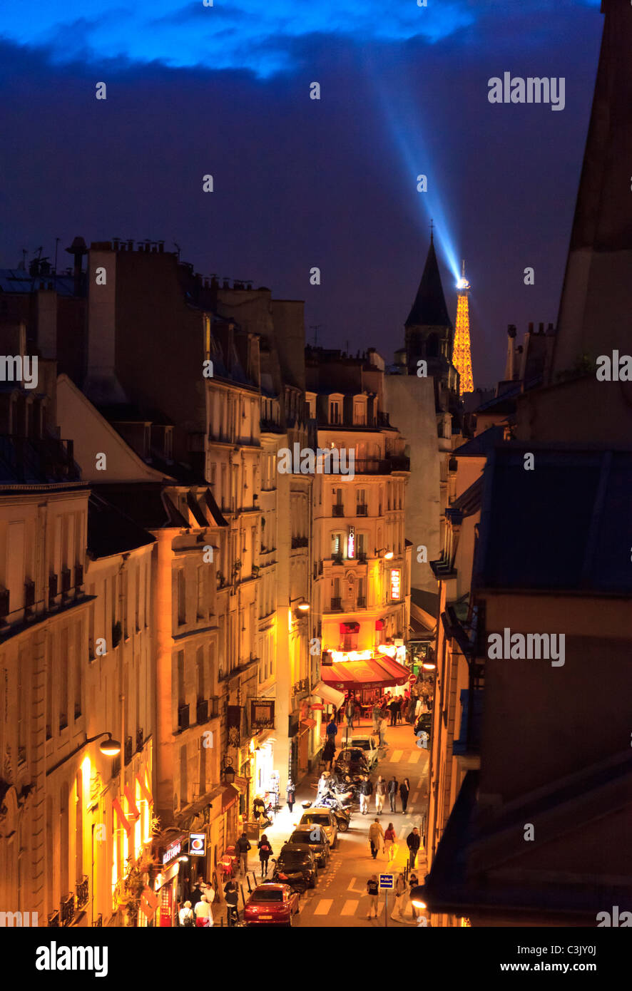 Eine beleuchtete Rue Saint-André des Arts bei Nacht mit dem Eiffelturm im Hintergrund, Paris Stockfoto