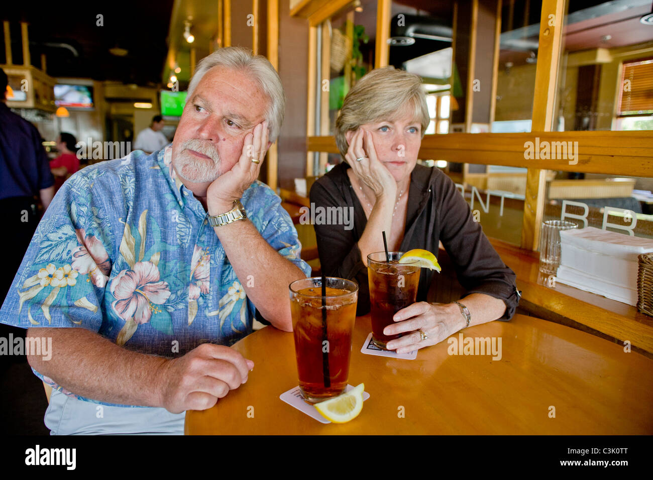 Ein Ehepaar mittleren Alters erschien über Eistee zusammen in einem Restaurant in Long Beach, Kalifornien, gleichgültig gegenüber anderen Unternehmen. MODELL Stockfoto