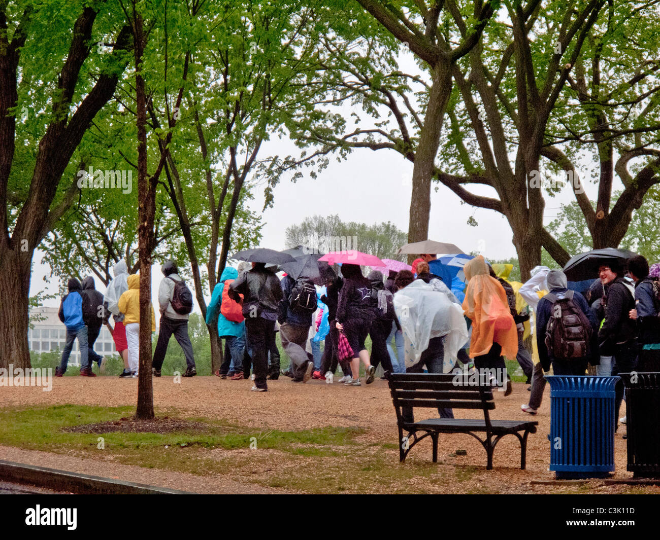 Mit Regenjacken und Schirme, folgen Sie Touristen eine Anleitung an einem regnerischen Tag auf der National Mall in Washington, D.C. Stockfoto