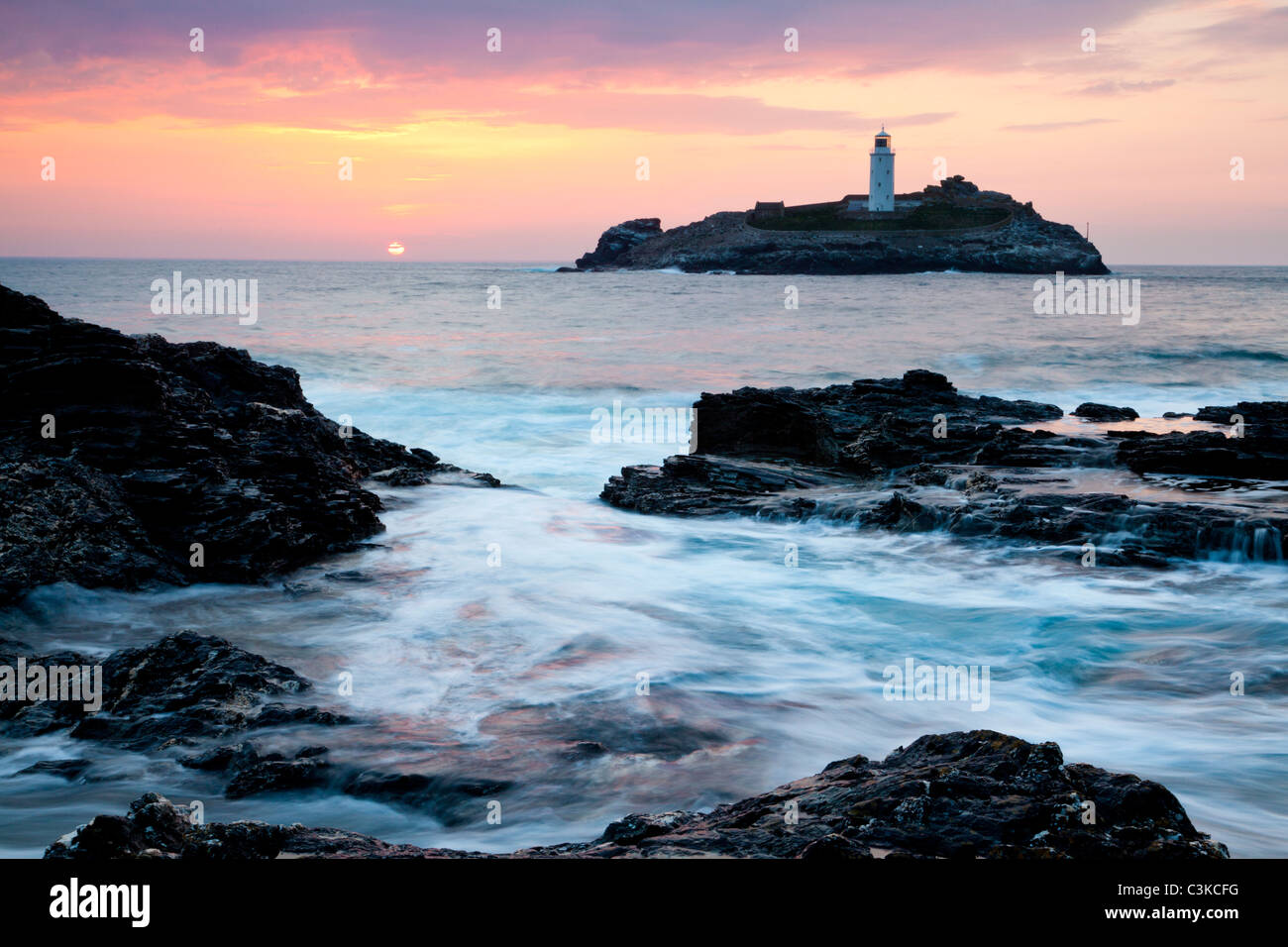 Sonnenuntergang auf den Klippen am Godrevy Godrevy Insel mit Leuchtturm im Hintergrund. Stockfoto