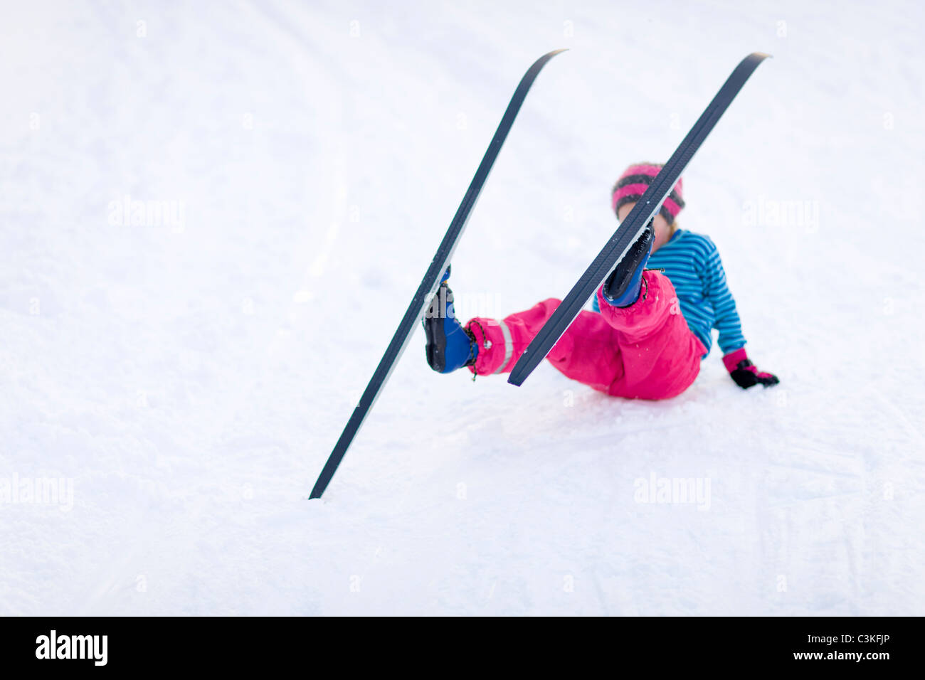 Junges Mädchen Ski- und herunterfallen Stockfoto