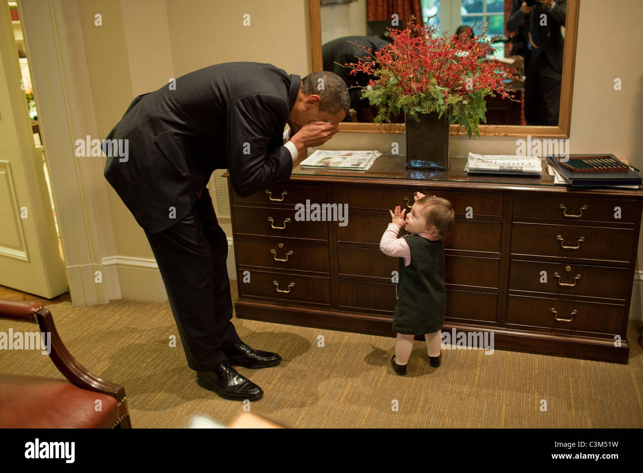 Präsident Barack Obama spielt mit der Tochter von Emmett Beliveau, Direktor des voraus, in der äußeren Oval Office Stockfoto