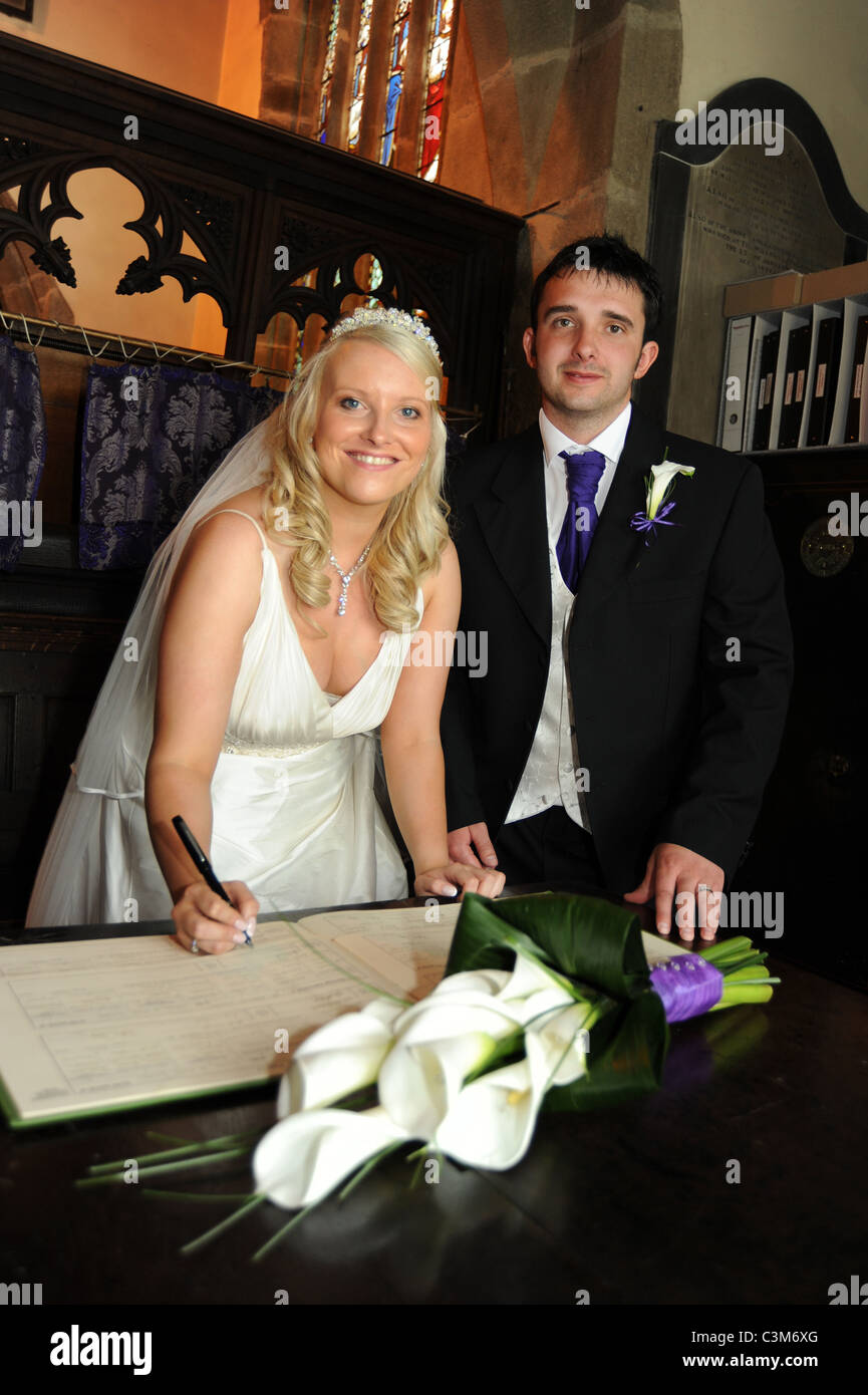 Ein paar Zeichen die Ehe während der Zeremonie bei ihrer Hochzeit registriert Stockfoto