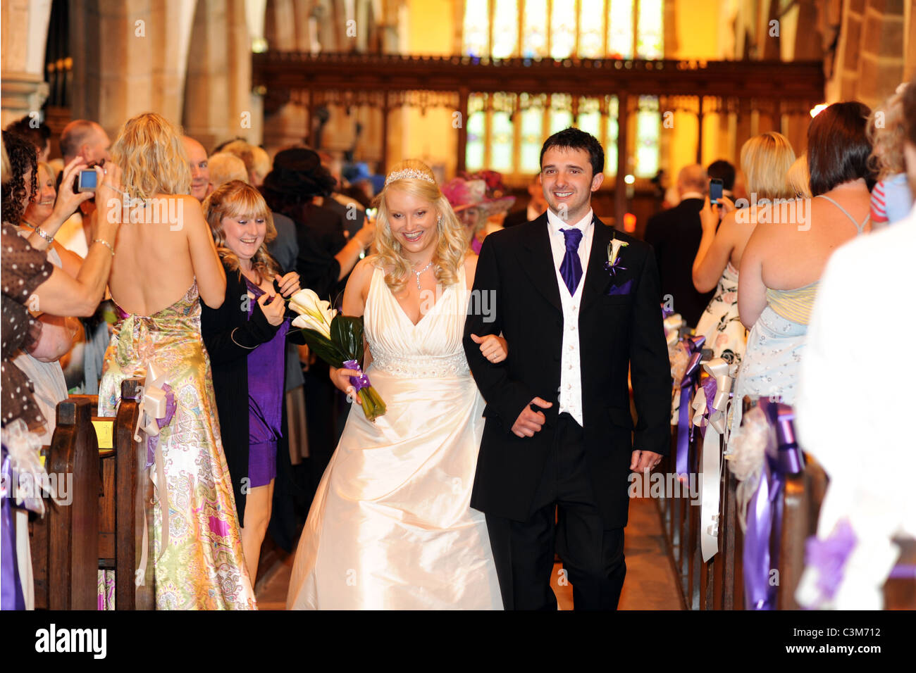 Ein frisch verheiratetes Paar Fuß zurück durch den Gang nach der Heirat. Stockfoto