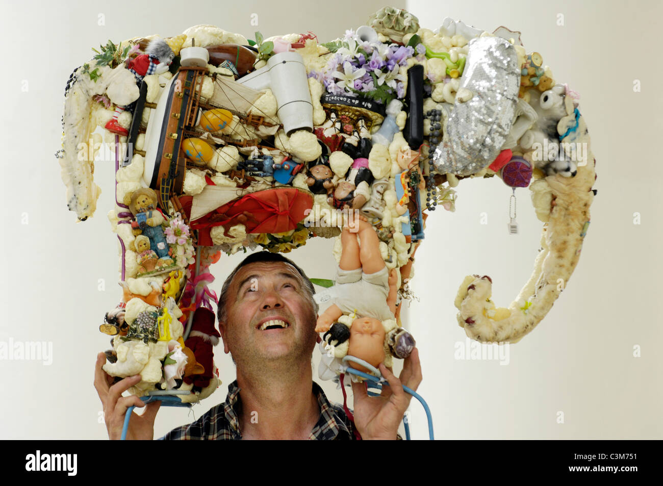 Bildhauer Anthony Heywood hebt seine Skulptur "Erde Elephant" aus recycelten Objekte gemacht. Stockfoto