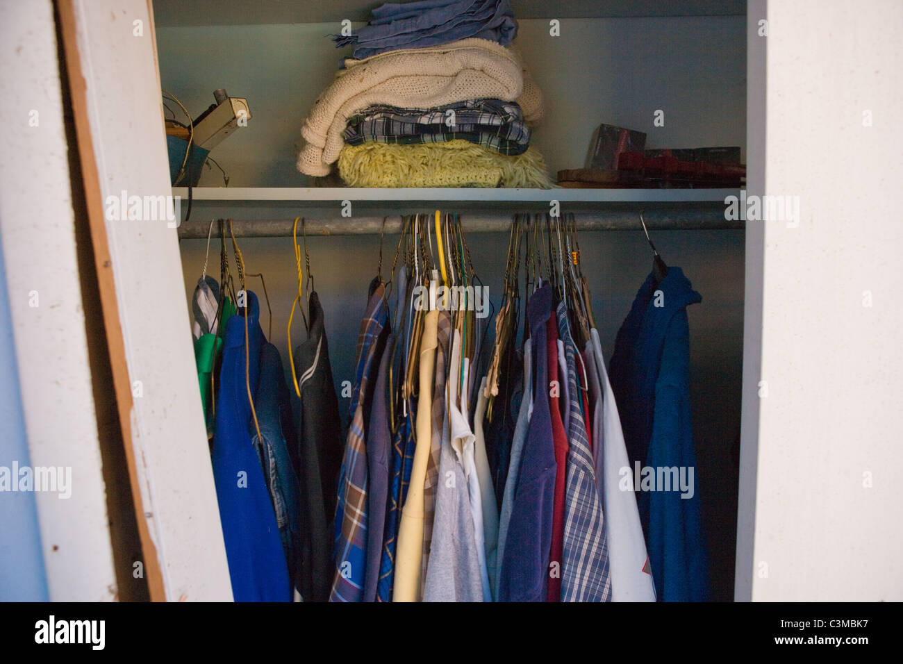 Schrank mit Mann t-Shirts, Pullover und decken. Stockfoto