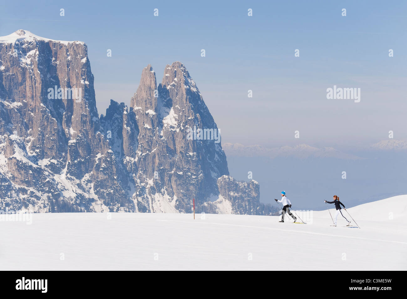 Italien, Trentino-Alto Adige, Alto Adige, Bolzano, Seiser Alm, zwei Frauen, Ski-Langlauf in der Nähe von Berg Stockfoto