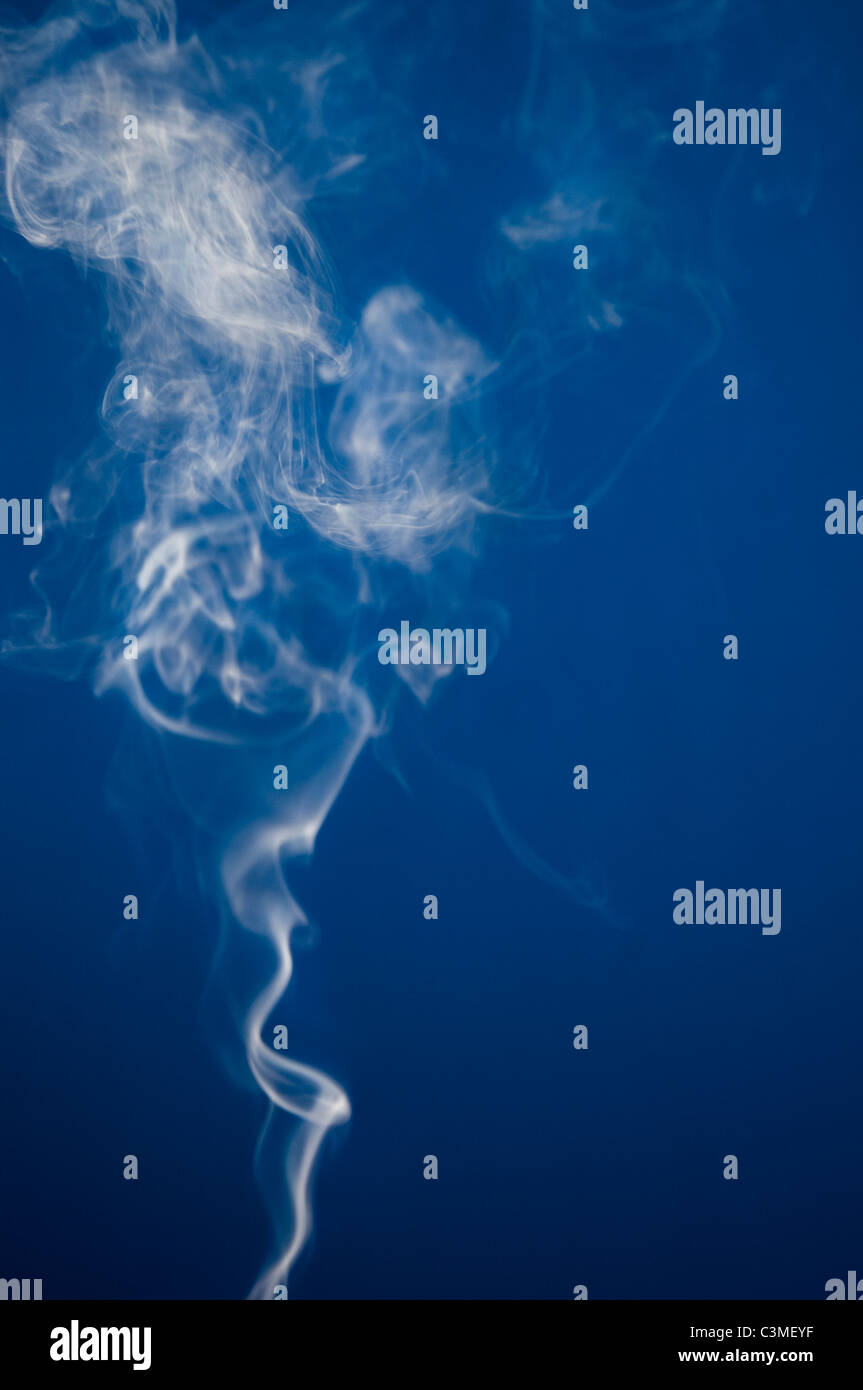 Rauch der Zigarette vor blauem Hintergrund Stockfoto