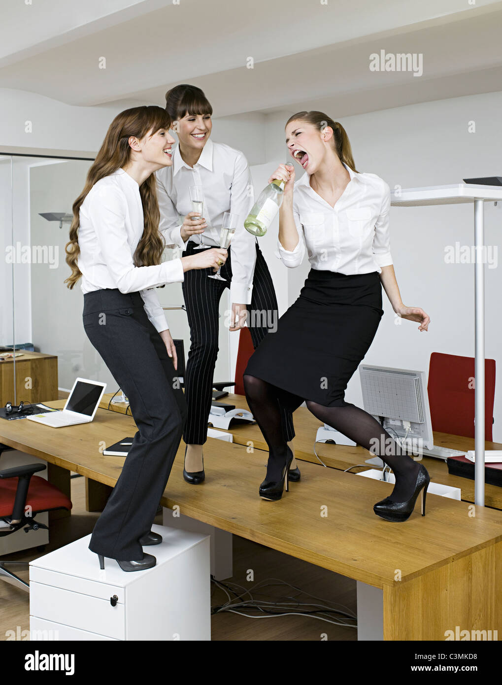 Deutschland, Köln, junge Frauen, die Spaß mit Sekt im Büro Stockfotografie  - Alamy