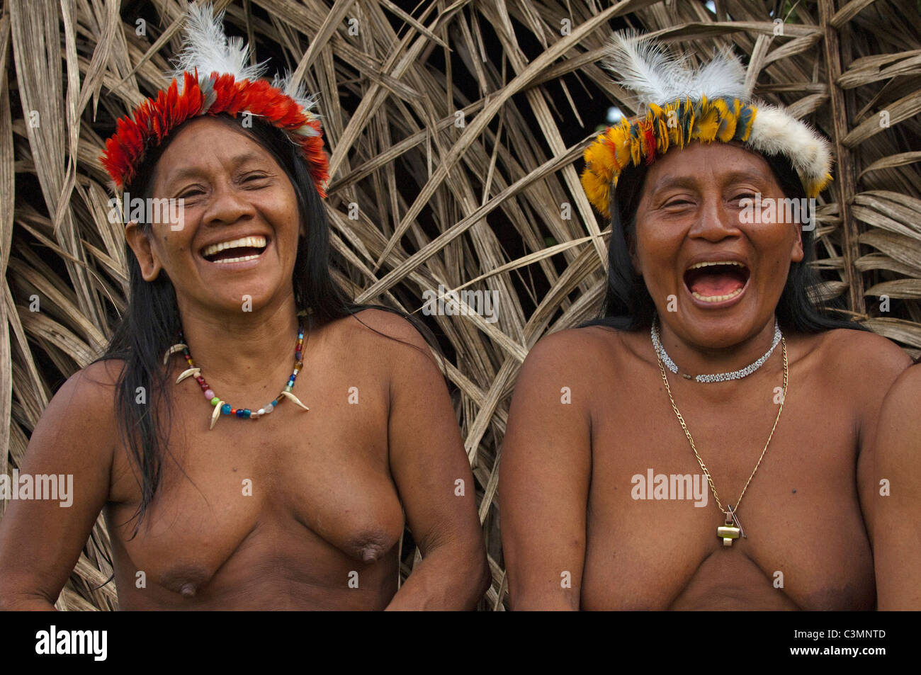 Huaorani Indianer: Lachen Frauen (Awame Gomoke und Dete Iteka). Beide tragen Kronen gekrönt mit Harpyie Federn Stockfoto