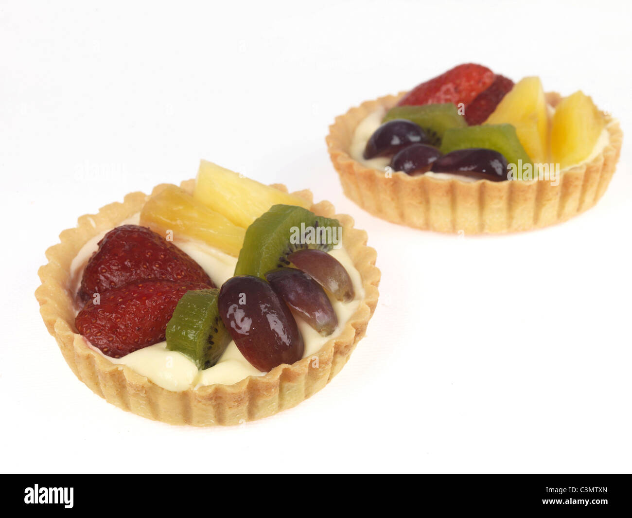 Frisch zubereitete Sommer Obstkuchen mit Kiwis Erdbeeren, Trauben und Ananas in einer gebackenen Teig Flan Unterseite Ohne Menschen gegen Weiße Stockfoto