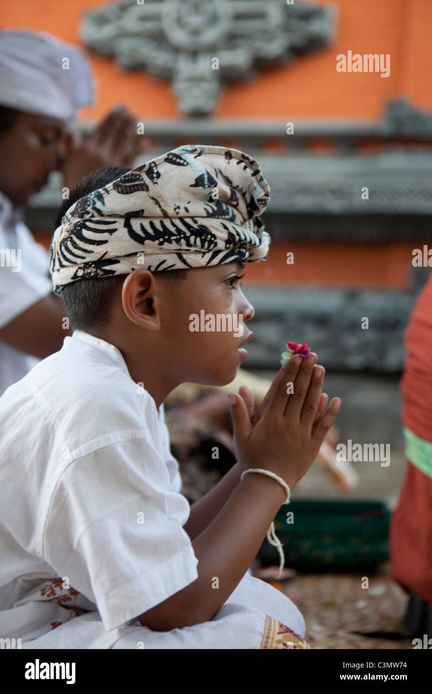 Indonesien, Insel Bali, Tejakula Dorf, Pura Maksan Tempel. Junge im feierlichen Kleid zu beten. Stockfoto