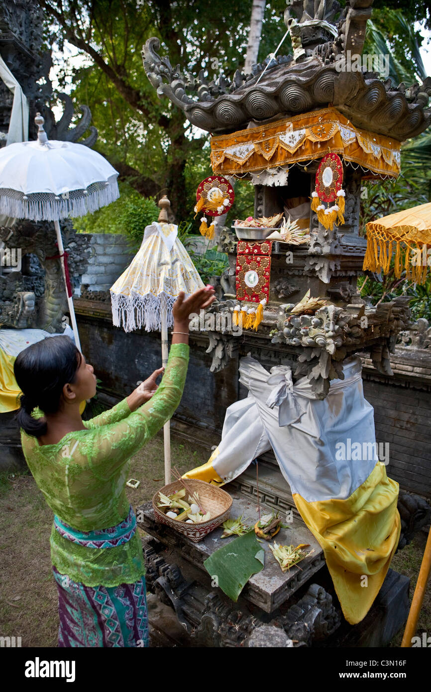 Indonesien, Insel Bali, in der Nähe von Tejakula Dorf, Gaia Oasis Resort. Frau verehren im Haus Tempel. Stockfoto