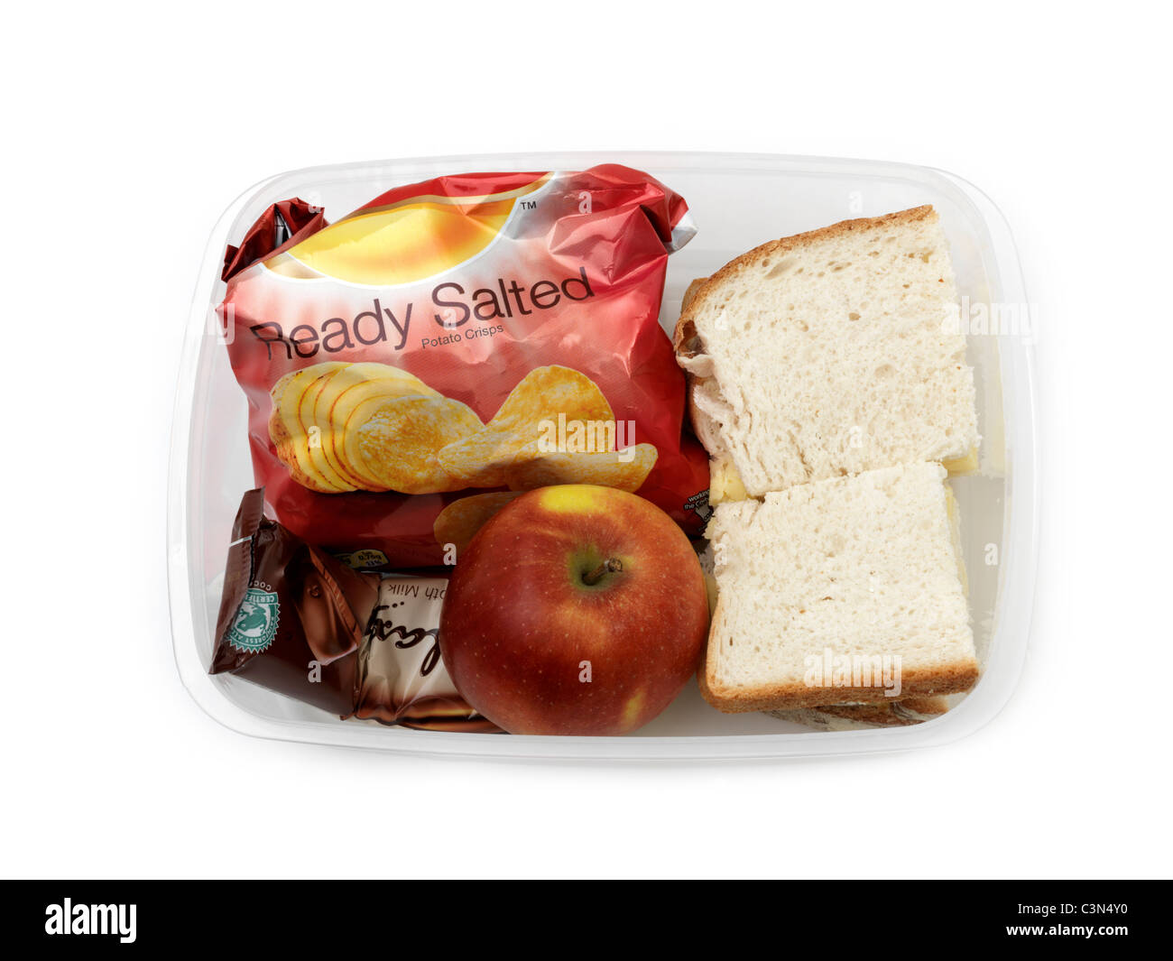 Ein Lunchpaket - Weißbrot-Käse-Sandwiches, Packung Chips, Schokoriegel und einen Apfel In eine Lunchbox Stockfoto