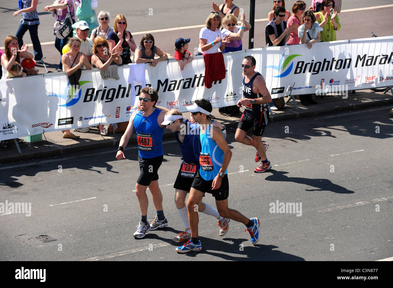 Brighton Marathon 2011 - gegenseitig erschöpften Läufer die Ziellinie Stockfoto