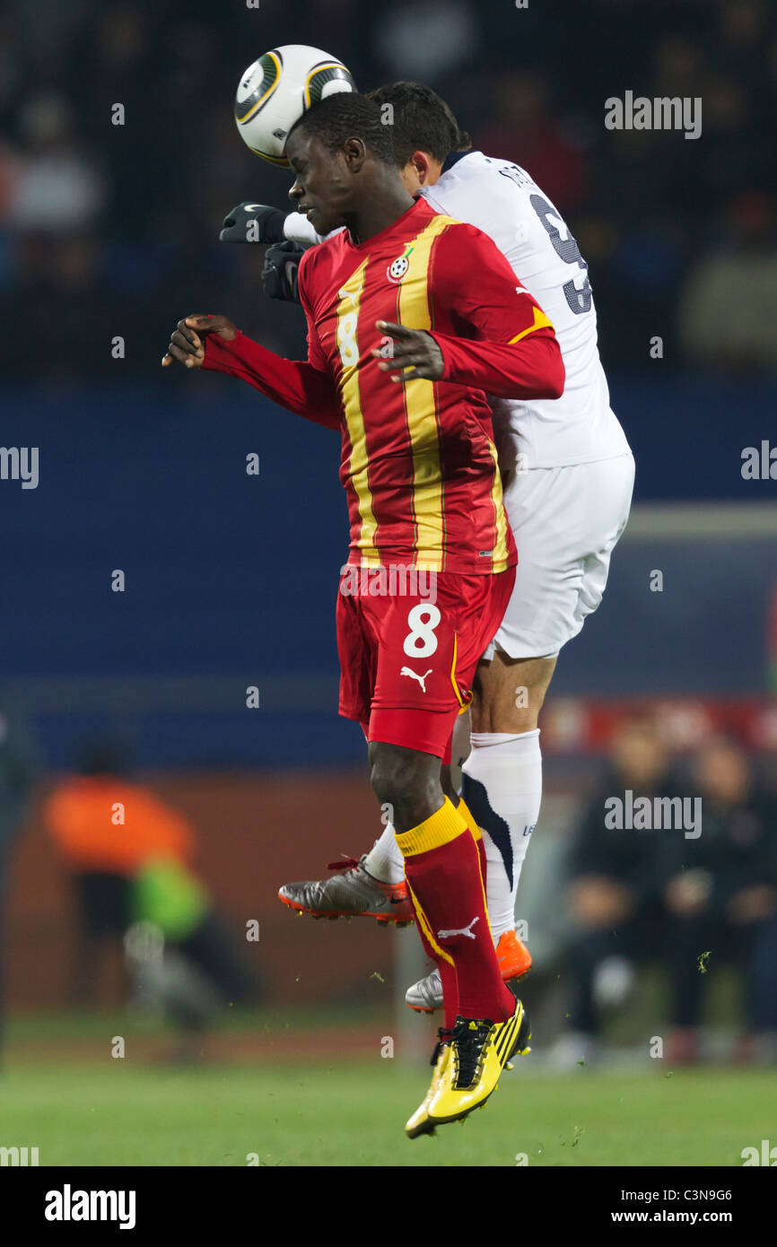 Jonathan Mensah von Ghana (l) und Herculez Gomez von den United States (r) wetteifern um einen Header während ein 2010 WM-Fußballspiel. Stockfoto