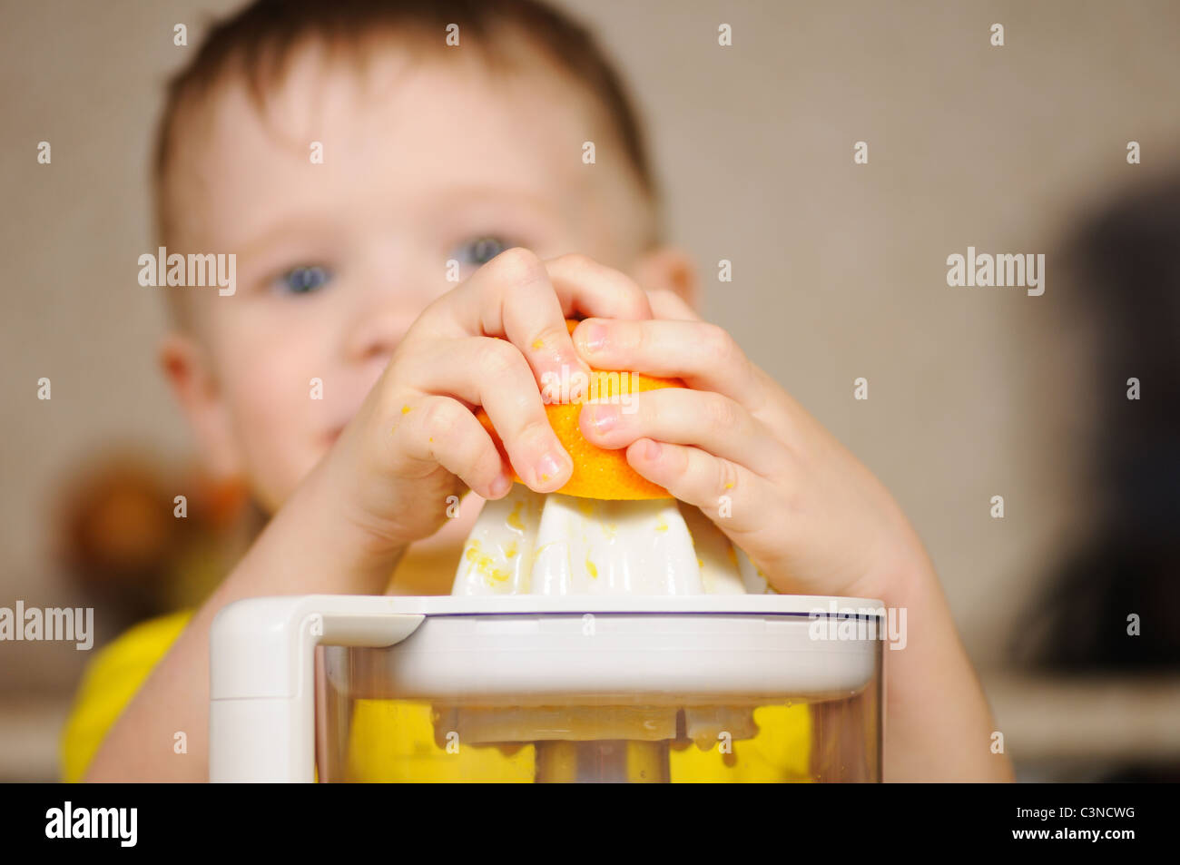 Das Kind in eine gelbe Weste, auswringen, Saft von einer orange Stockfoto
