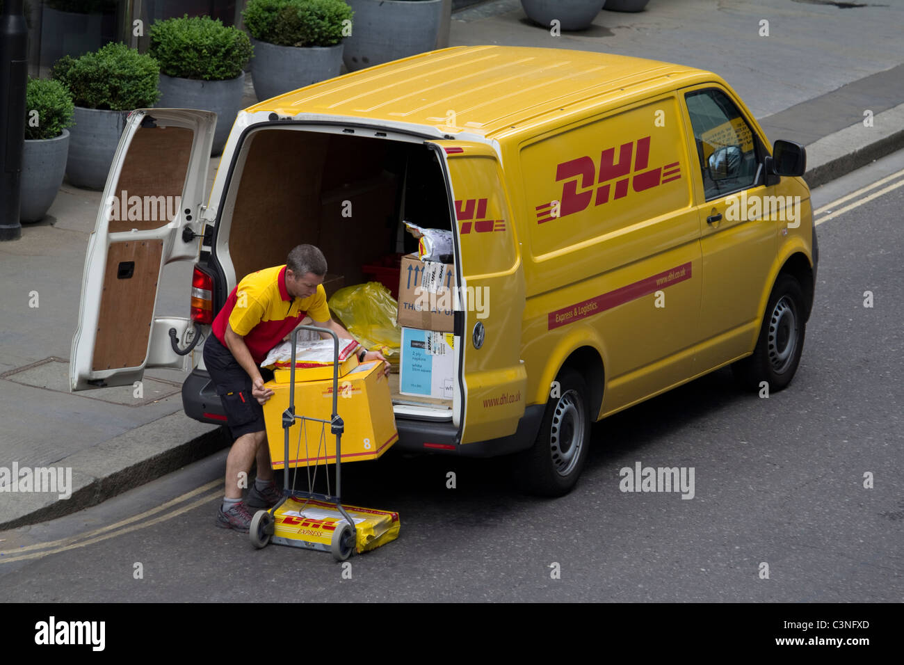 DHL Fahrer entladen Lieferwagen in der Londoner City Stockfoto