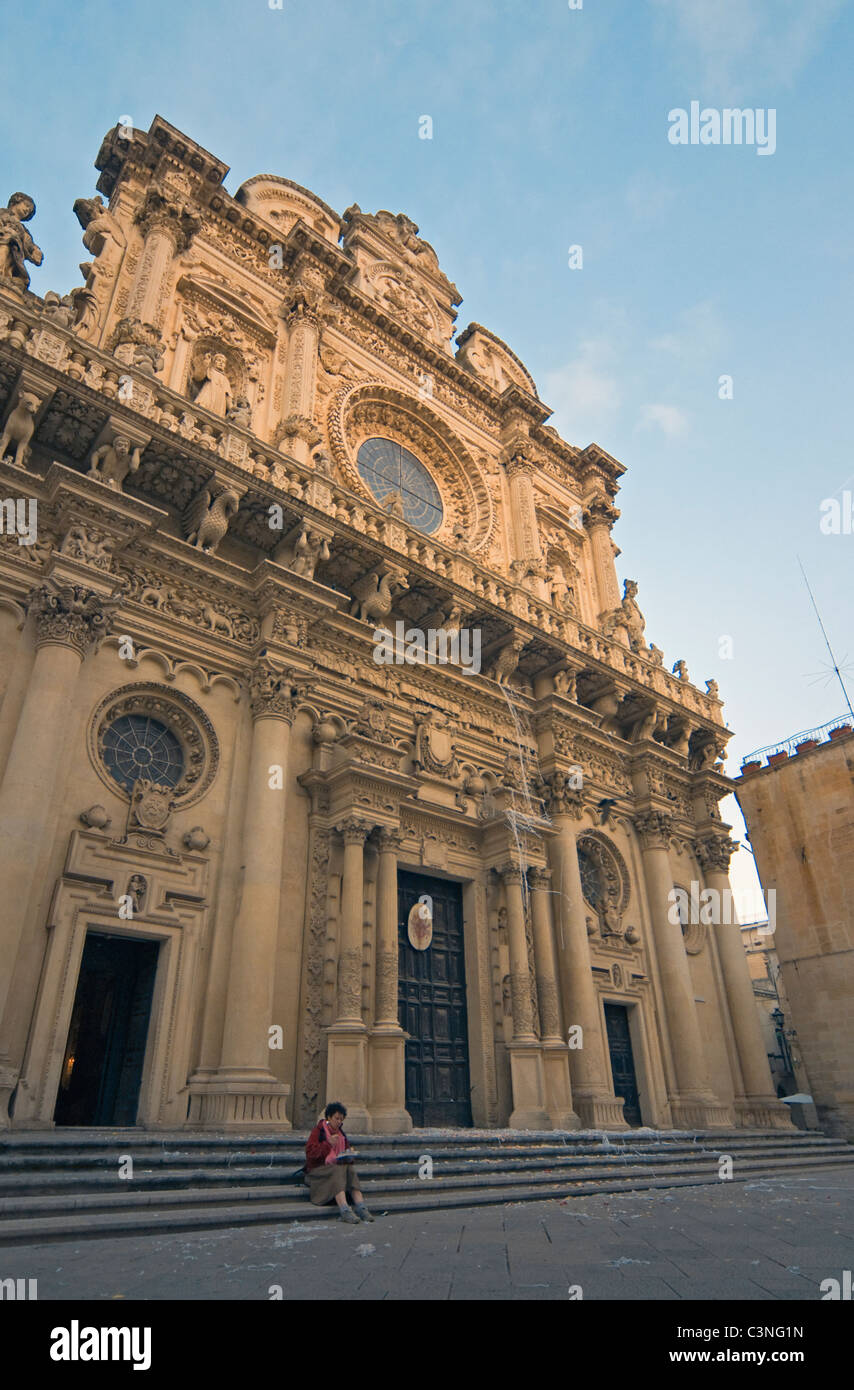 Frau auf der Treppe der barocken Basilika di Santa Croce (Kirche des Heiligen Kreuzes) in Lecce, Apulien (Puglia), Süditalien Stockfoto