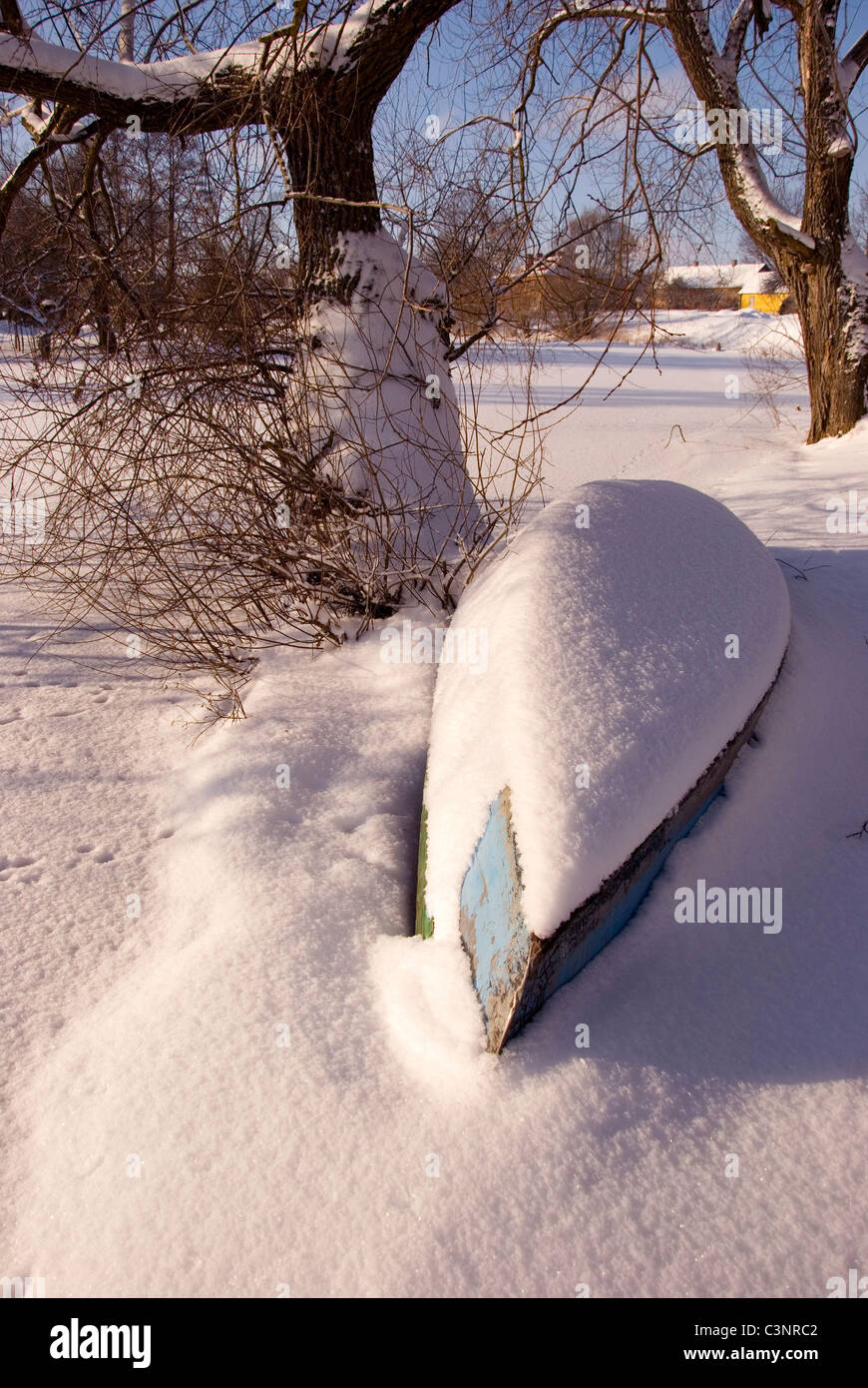 Boot in der Nähe der Baum Winter schneebedeckt am Ufer des Flusses. Stockfoto